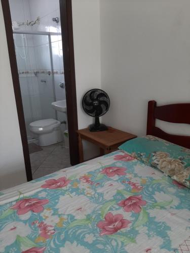 a bedroom with a bed and a bathroom with a toilet at Sobrado Em Matinhos Pr in Matinhos