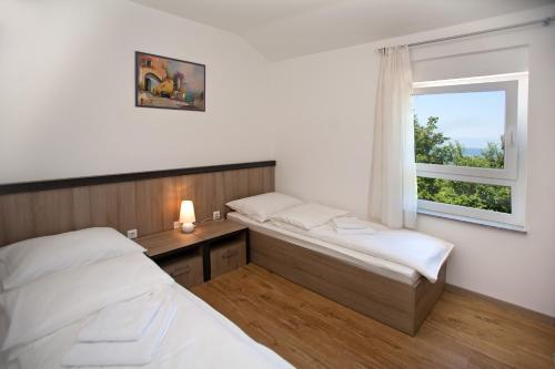 sypialnia z dwoma łóżkami i oknem w obiekcie Apartments Maslina III w mieście Nijvice