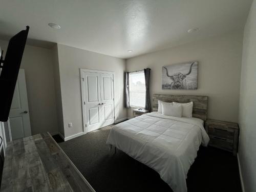 a bedroom with a bed and a antelope picture on the wall at Longhorn Flats in Loving