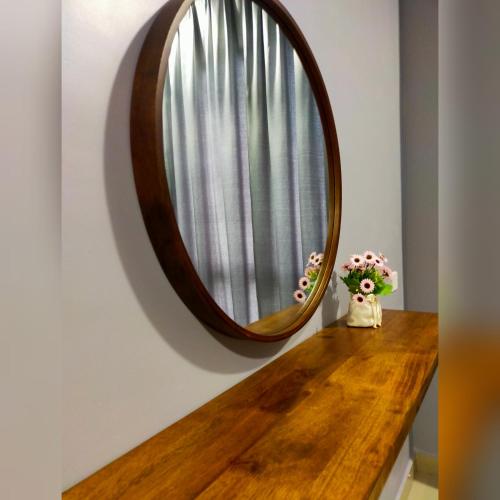 a mirror on a wall next to a wooden table at D'RZ Muslim Seaview Homestay Bali Residence in Melaka