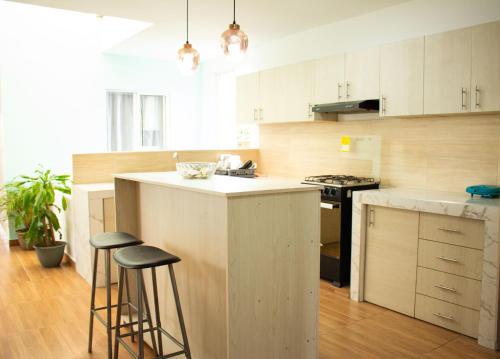 una cocina con armarios blancos y una isla con taburetes. en Hotel Brisas De Calima, en Cali