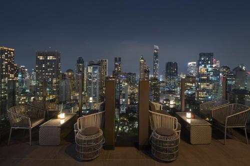 a view of a city skyline at night with chairs and lights at Hotel Indigo Bangkok Wireless Road by IHG in Bangkok