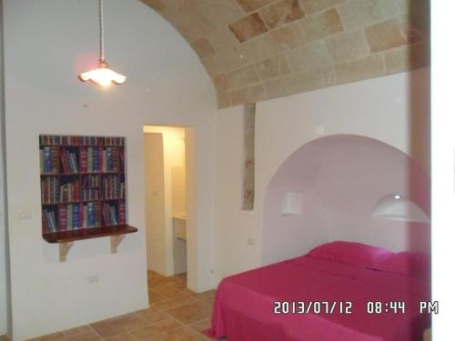 een slaapkamer met een bed en een boekenplank met boeken bij Lovely Studio In Villa Near The Sea in Leuca