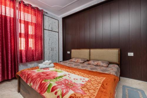 a bedroom with a large bed with red curtains at (TF) Entire Indpndnt Private 2 BHK Flat,Nr Airport in New Delhi