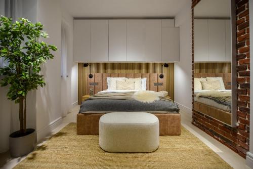 a bedroom with a bed and a chair and a plant at Modern Symphony - Stunning Central Apartment in Bucharest