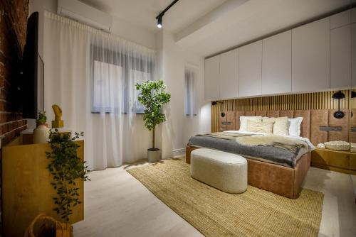 a bedroom with a king sized bed and a table at Modern Symphony - Stunning Central Apartment in Bucharest