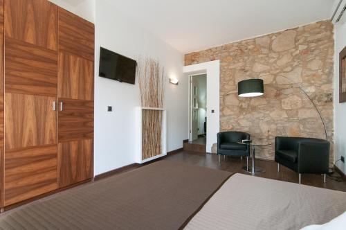 1 dormitorio con 1 cama, 2 sillas y TV en Alos Apartments Paseo de Gracia-Diagonal en Barcelona