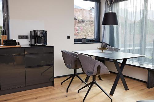 a kitchen with a table and two chairs and a microwave at dasVolks in Oberstdorf