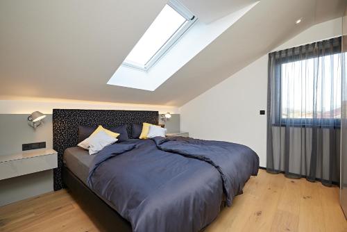 a bedroom with a large bed and a skylight at dasVolks in Oberstdorf