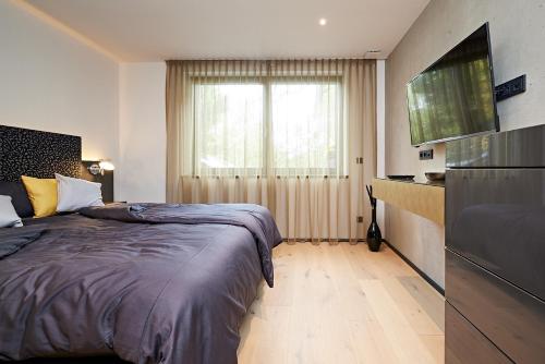 a bedroom with a bed and a large window at dasVolks in Oberstdorf