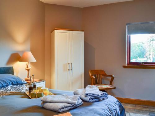 a bedroom with a bed with towels on it at Garden Cottage in Coldingham