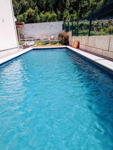 a swimming pool with blue water in a yard at Magníficos Dias Atlânticos in Moledo