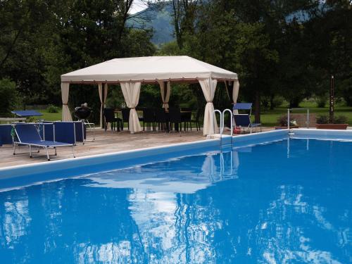 a gazebo with tables and chairs next to a swimming pool at Villa Casagrande in Vittorio Veneto