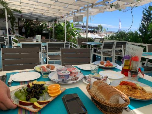 a table with plates of food on top at Majki Beach Apartments in Sarandë