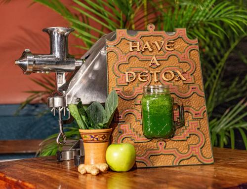 een boek zittend op een tafel met een groene drank bij KACLLA, The Healing Dog Hostel in Lima