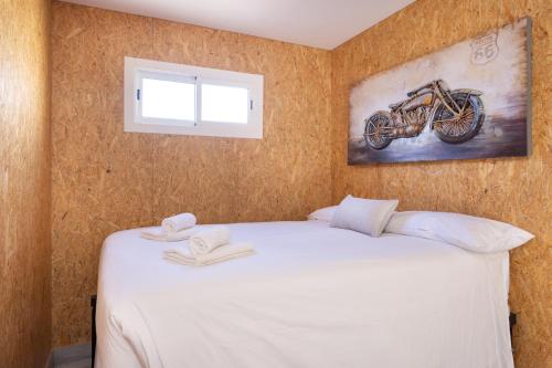 een slaapkamer met een bed met een foto van een motorfiets aan de muur bij Las Latas del Almendro 2 in Santiago del Teide