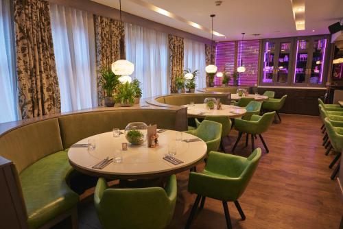 a dining room with tables and green chairs at Tigerlily in Edinburgh