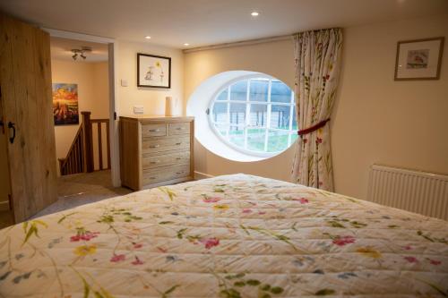 Un dormitorio con una cama grande y una ventana en Rollestone Coach House en Shrewton