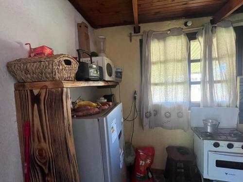 a kitchen with a small refrigerator with a basket on top of it at Lo de Fabi in La Coronilla
