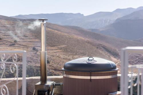 a barrel sitting on top of a table with a mountain at Touda Ecolodge Atlas Mountains in Zawyat Oulmzi