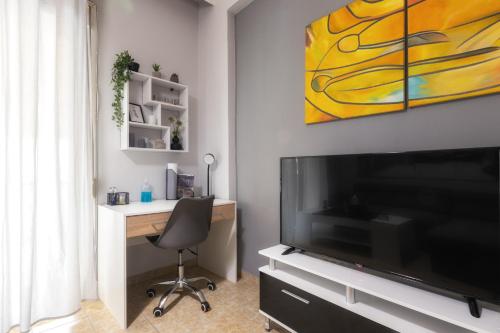 - un salon avec un bureau et une grande télévision dans l'établissement Renovated penthouse in the center of Larissa, à Larissa