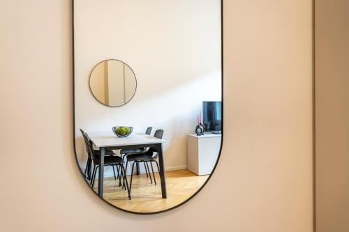 uno specchio appeso a un muro con tavolo e sedie di Petrin Tower Residence a Praga