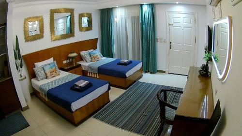 a hotel room with two beds and a table at Deluxe Apartment Delta Sharm in Sharm El Sheikh