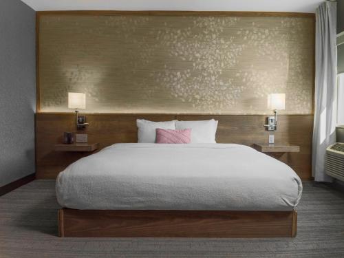a bedroom with a large bed and two night stands at voco Niagara Falls - The Cadence by IHG in Niagara Falls