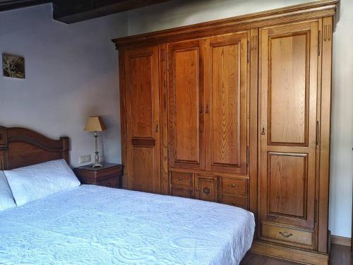 a bedroom with a bed and a wooden cabinet at LA CASA ROJA in Pechón