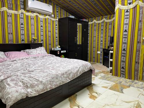 a bedroom with a bed in a room with yellow walls at مزرعة دريم للتأجير 
