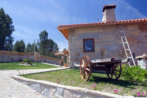 une maison en pierre avec un wagon en bois devant elle dans l'établissement Retiro de Basto, à Castelbuono