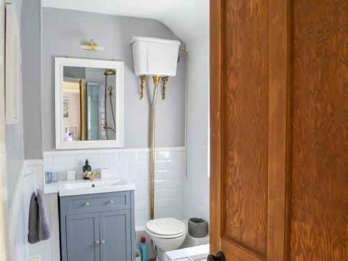 a bathroom with a sink and a toilet and a mirror at Greenwood Cottage in Longframlington