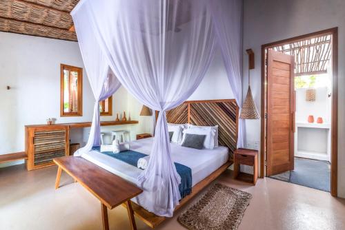 a bedroom with a bed with a mosquito net at Muita Paz in Atins