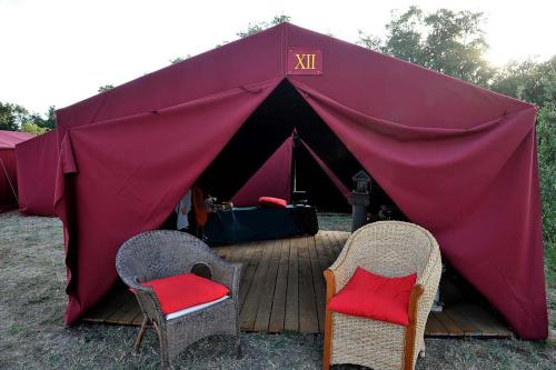 ein rotes Zelt mit zwei Stühlen davor in der Unterkunft Tenda a Roma World in Rom