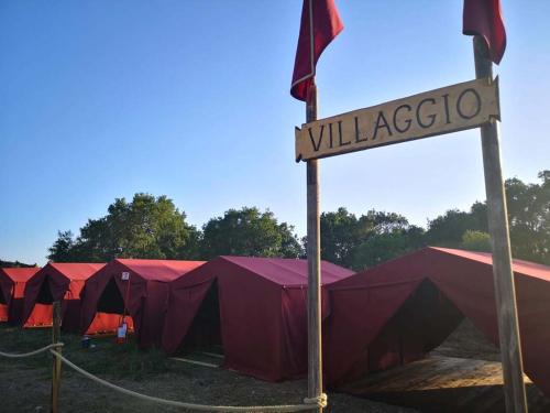 una fila di tende rosse con un cartello davanti di Tenda a Roma World a Roma