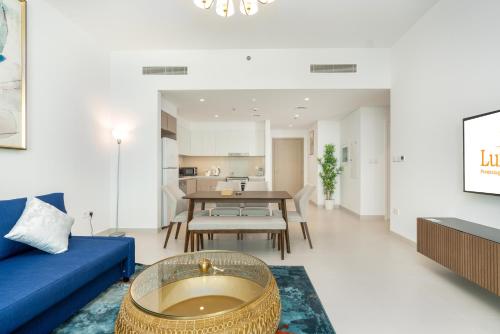 a living room with a blue couch and a table at Lux BnB The Grand Creek Harbor Views in Dubai