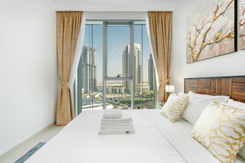 a bedroom with a white bed with a large window at Lux BnB The Grand Creek Harbor Views in Dubai
