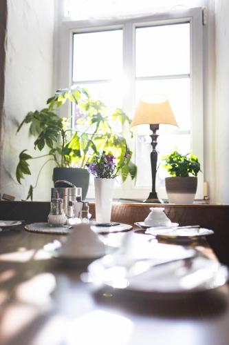 a table with plates and a lamp and plants in a window at Pension Friedrichshof in Bad Klosterlausnitz