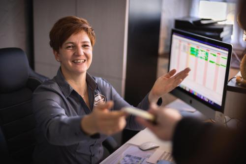 a woman sitting at a desk in front of a computer at Pension Friedrichshof in Bad Klosterlausnitz