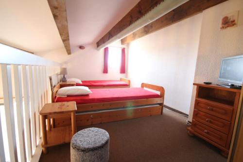 une petite chambre avec deux lits et une télévision dans l'établissement Maison de vacances, 4 -6 couchages, 200m de la mer, Residence securisee LES SENTOLINES, PORTIRAGNES PLAGE LRSEN47, à Portiragnes