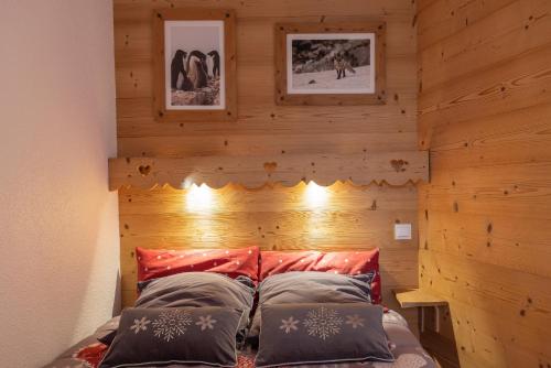 Bett in einem Zimmer mit einer Holzwand in der Unterkunft Amanuq lovely apartment in Chamonix-Mont-Blanc