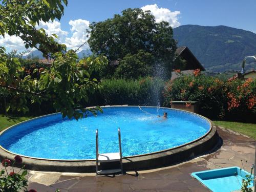 a person swimming in a pool with a fountain at Hotel Garni Lichtenau in Schenna