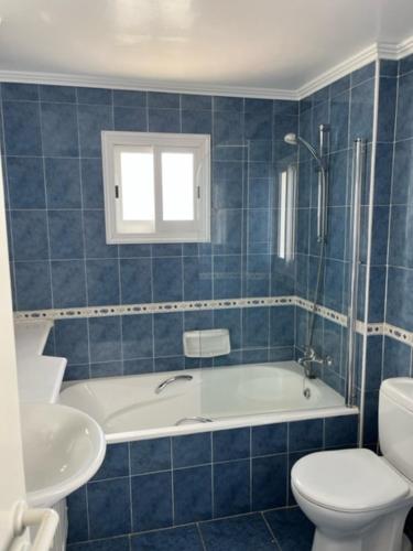 een badkamer met een bad, een toilet en een wastafel bij Sky Villa in Paphos City