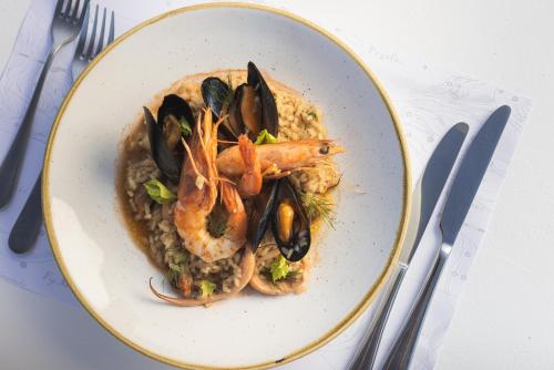 a plate of food with shrimp and risotto at Panorama Inn in Lithakia