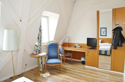 een slaapkamer met een bureau, een bed en een stoel bij Hotel Goldener Adler Garni in Hallstadt