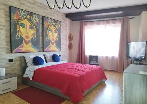 a bedroom with a large red bed and a tv at CASA VACANZA GIAVENO - 8 KM Sacra di San Michele in Giaveno