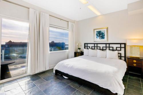 a bedroom with a large bed and a large window at Pier View Suites - Pacific Premier Suite in Cayucos