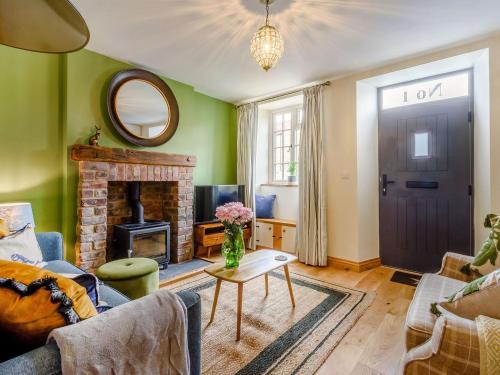 a living room with a fireplace and a door at 1 Chapel Terrace in Ebberston