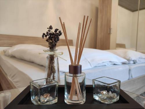 a table with three glass vases and a bed at Appartement Ferienhaus Sonnenhain in Sollenau