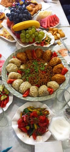 a table with several plates of food on it at Ala-Kul guesthouse in Altyn-Arashan in Karakol